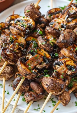 Balsamic garlic grilled mushroom skewers ready to serve on a platter.