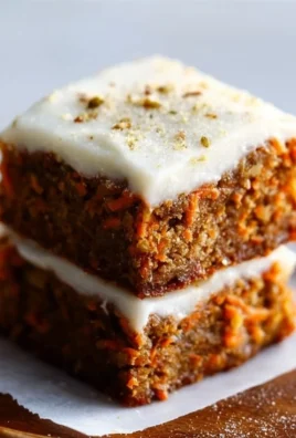 Delicious carrot cake bars with cream cheese frosting served on a plate