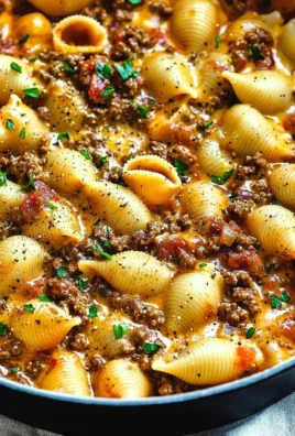 Creamy beef and shells pasta dish with cheese served on a plate