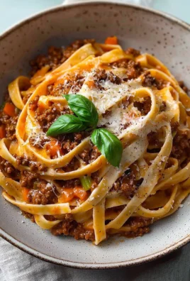Creamy Fettuccine Bolognese served in a rustic bowl with fresh herbs