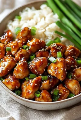 A plate of easy high protein sesame chicken with sesame seeds and vegetables