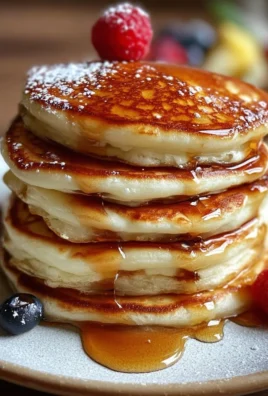 Fluffy Greek Yogurt Pancakes stacked with fresh fruit on top