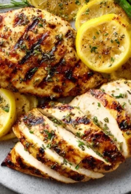 Grilled lemon chicken served with fresh herbs and lemon slices on a plate