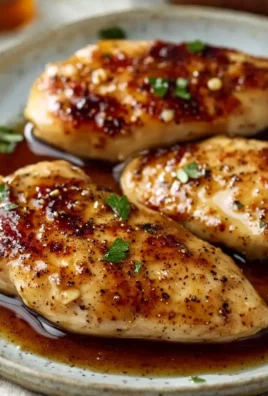 Plate of Honey Garlic Chicken Breast garnished with herbs.