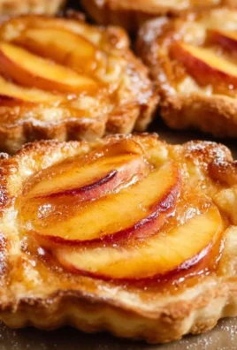 Mini peach and cream cheese tarts on a white plate
