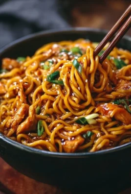 Plate of Sticky Garlic Chicken Noodles garnished with herbs