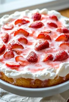Fluffy Strawberry Angel Food Cake topped with fresh strawberries and whipped cream.