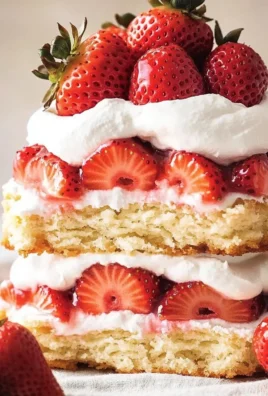 Delicious strawberry shortcake topped with fresh strawberries and whipped cream.