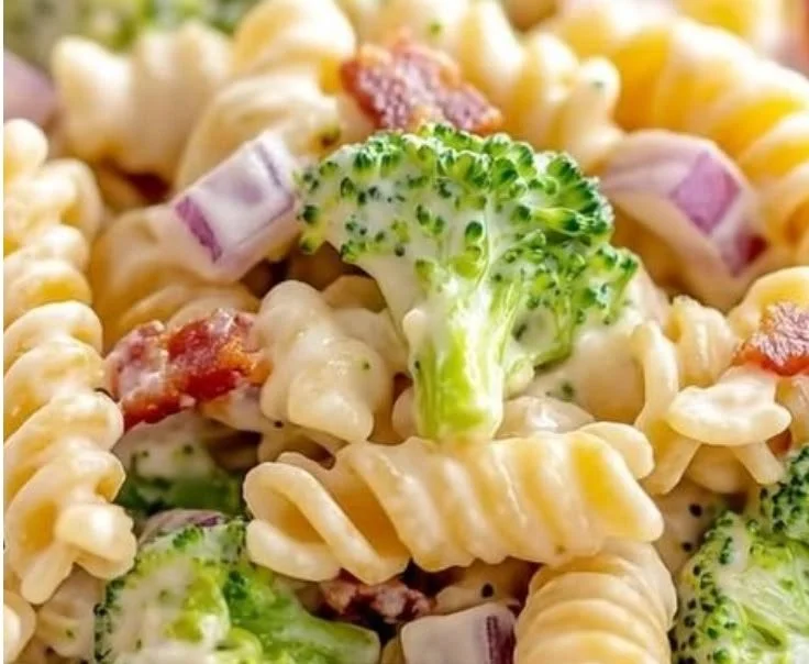 Delicious broccoli pasta salad in a bowl with colorful veggies and dressing.