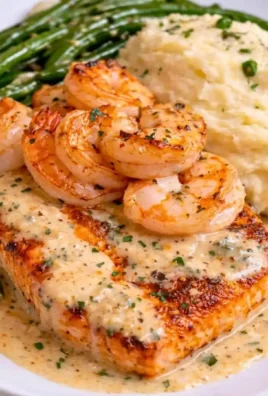 Cajun shrimp and salmon served with creamy garlic sauce on a plate