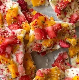 Delicious frozen yogurt bark topped with fresh strawberries and mango slices