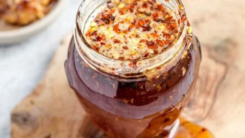 Homemade hot honey in a jar with chili peppers and drizzle on food