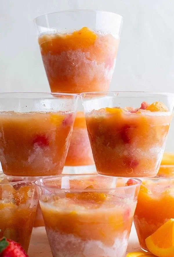 Colorful frozen fruit cups filled with a variety of berries and other fruits