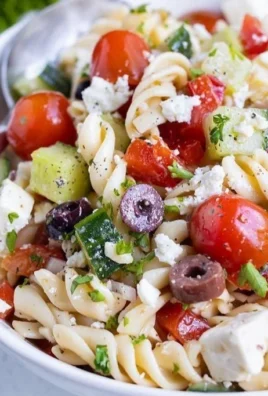 Delicious Greek Pasta Salad with fresh vegetables, olives, and feta cheese.