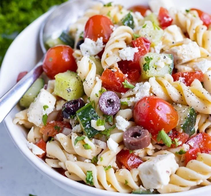 Delicious Greek Pasta Salad with fresh vegetables, olives, and feta cheese.