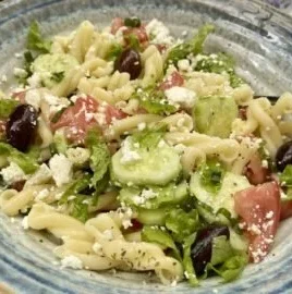 Delicious Greek pasta salad featuring olives, feta, and fresh vegetables.