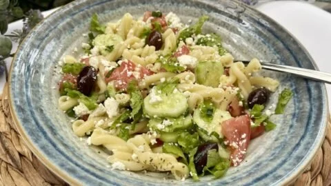 Delicious Greek pasta salad featuring olives, feta, and fresh vegetables.