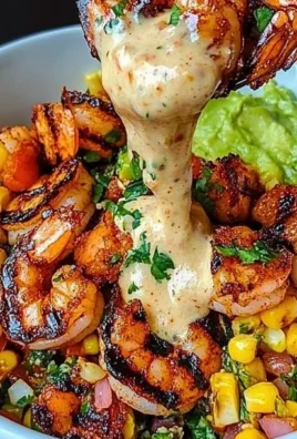 Grilled shrimp bowl with avocado, corn salsa, and creamy sauce on a plate