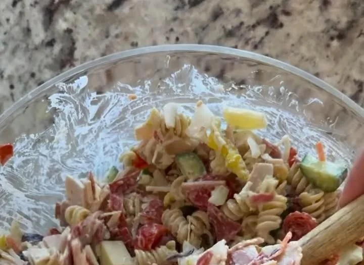 Colorful Grinder Pasta Salad with vegetables and dressing in a serving bowl