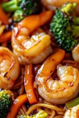 High-protein shrimp stir fry with colorful vegetables and noodles in a pan.