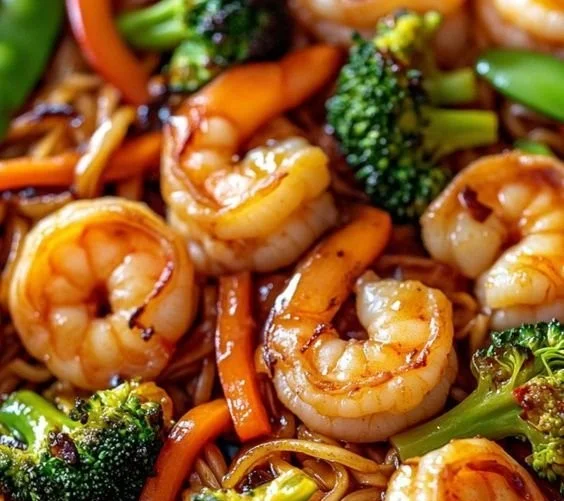 High-protein shrimp stir fry with colorful vegetables and noodles in a pan.
