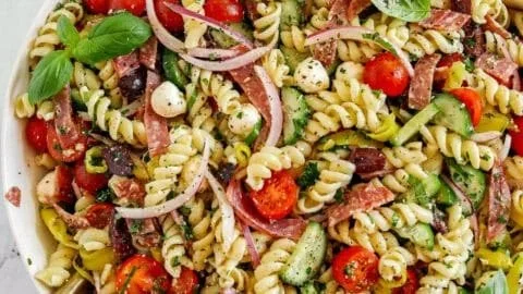 Bowl of colorful Italian pasta salad with vegetables and dressing