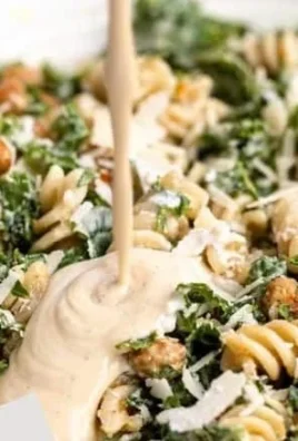 Bowl of Kale Caesar Pasta Salad with croutons and parmesan
