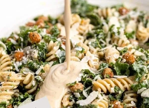 Bowl of Kale Caesar Pasta Salad with croutons and parmesan