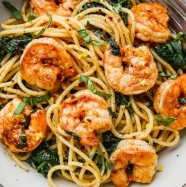 Delicious Lemon Garlic Shrimp Pasta with fresh spinach on a plate.