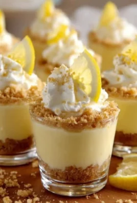 Mini lemon cheesecake cups with a buttery crust and lemon zest topping
