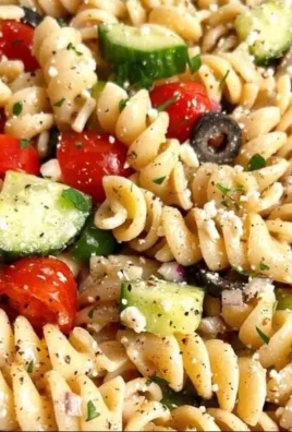 A vibrant bowl of pasta salad with fresh vegetables and dressing