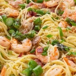 Creamy Shrimp Asparagus Carbonara garnished with parmesan and herbs