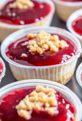 Strawberry cheesecake dessert cups with fresh strawberries and creamy topping.