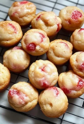Freshly baked strawberry yogurt mini muffins on a cooling rack
