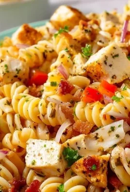Delicious chicken pasta salad with Italian dressing, garnished with fresh vegetables.