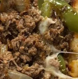 Delicious homemade Philly cheesesteak served with melted cheese and onions.