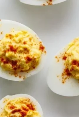 Plate of delicious deviled eggs garnished with paprika and herbs