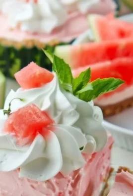 Delicious fluffy watermelon pie topped with whipped cream and fresh fruit.