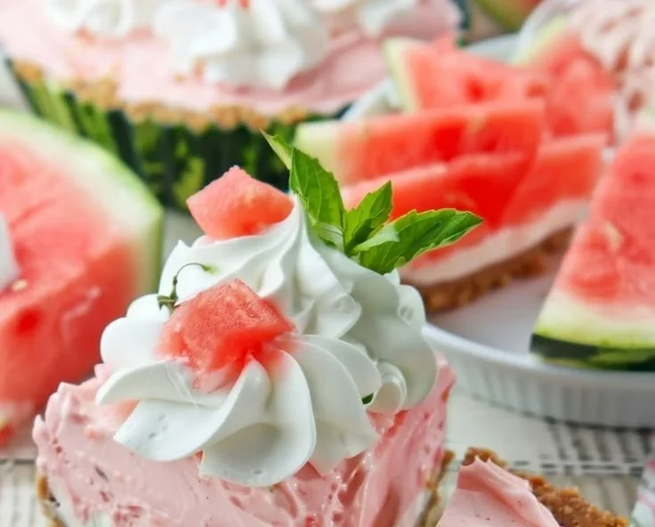 Delicious fluffy watermelon pie topped with whipped cream and fresh fruit.