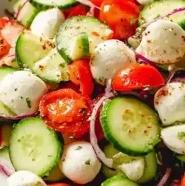 Fresh Cucumber Caprese Salad with mozzarella and cherry tomatoes on a plate