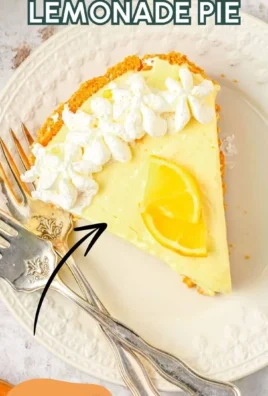 Delicious Frozen Lemonade Pie topped with whipped cream and lemon slices