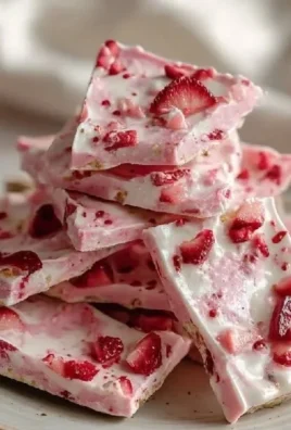 Frozen strawberry yogurt bark topped with fresh strawberries and blueberries