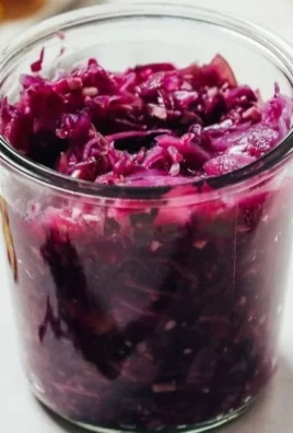 A jar of Ginger Apple Sauerkraut showcasing vibrant colors and healthy ingredients.