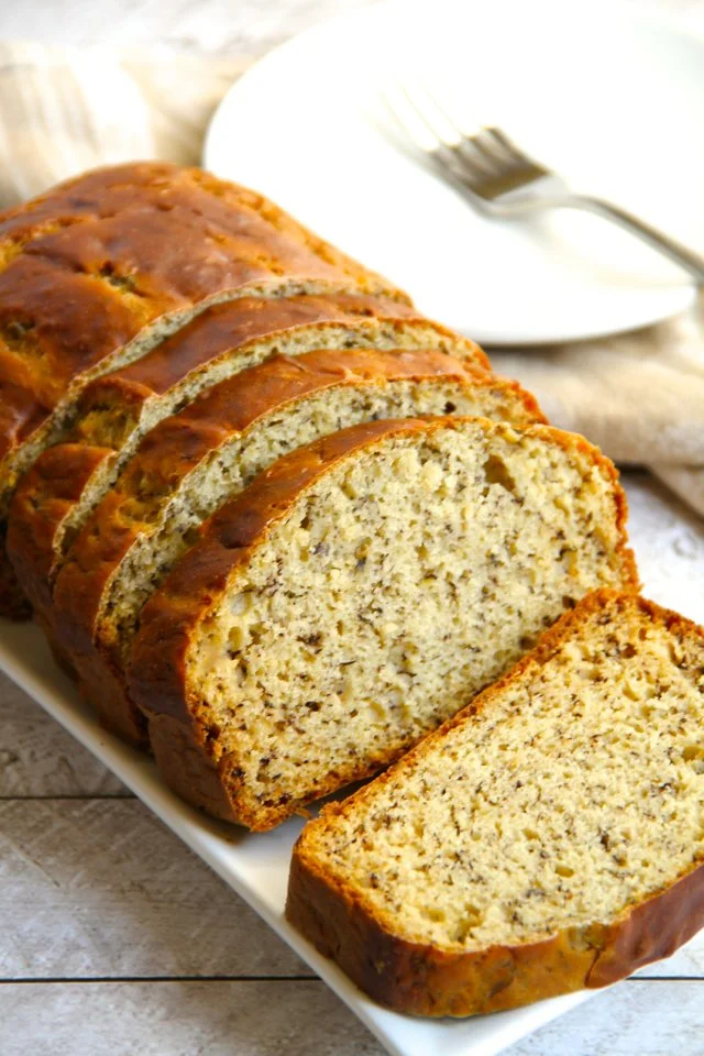 Delicious Greek yogurt banana bread slice on a plate with banana slices.