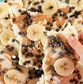 Kid-friendly frozen yogurt bark topped with peanut butter and bananas
