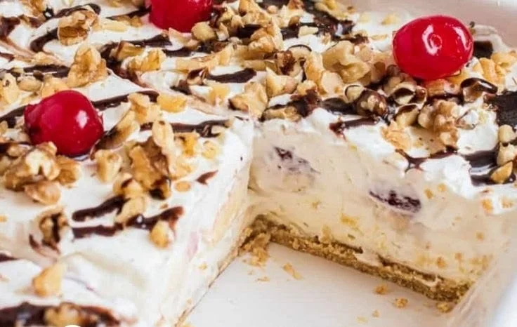 Delicious no bake banana split dessert topped with cherries and whipped cream