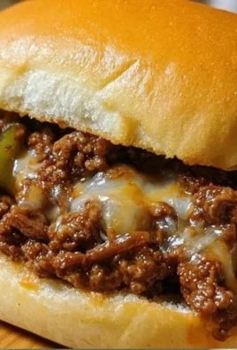 Plate of Philadelphia cheesesteak sloppy joes topped with melted cheese and peppers.