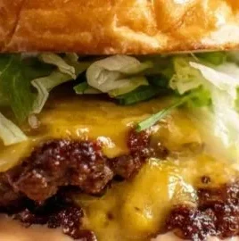 Smash burgers with house sauce served on a wooden platter