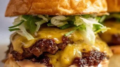 Smash burgers with house sauce served on a wooden platter