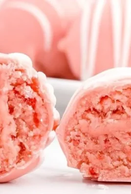 Plate of delicious strawberry cheesecake bites topped with fresh strawberries.